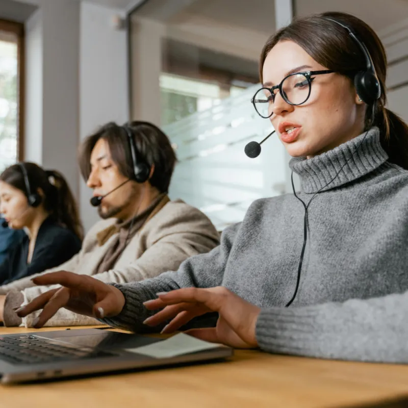 Customer service agents talking on headsets in an office Customer service agents talking on headsets in an office