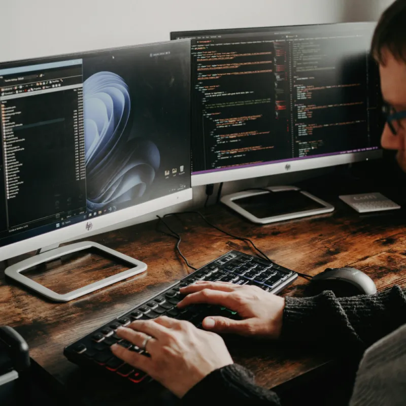 A app developer using 2 monitors, coding and using AI tools to increase speed and efficiency A app developer using 2 monitors, coding and using AI tools to increase speed and efficiency