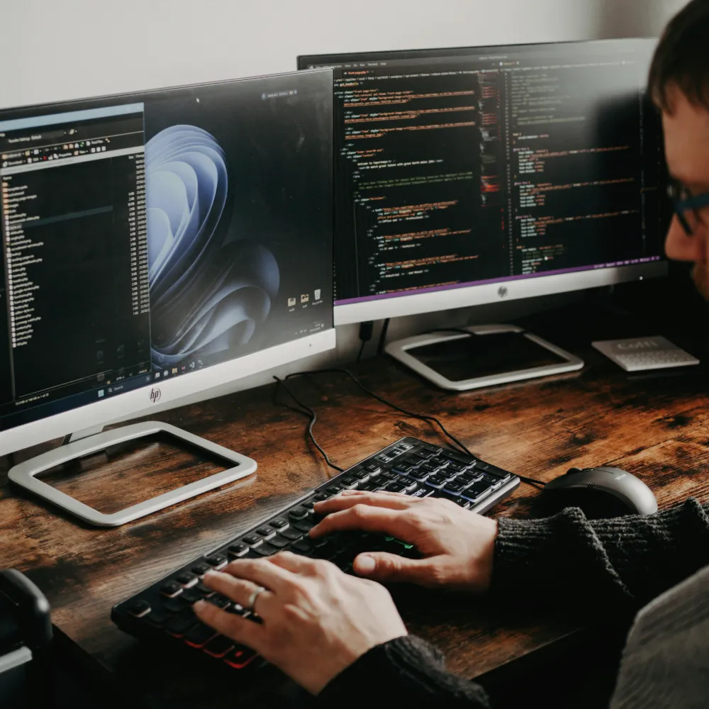 A app developer using 2 monitors, coding and using AI tools to increase speed and efficiency A app developer using 2 monitors, coding and using AI tools to increase speed and efficiency