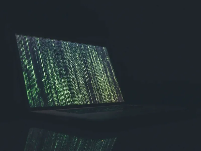 matrix-style laptop with text going down the screen, symbolising encryption