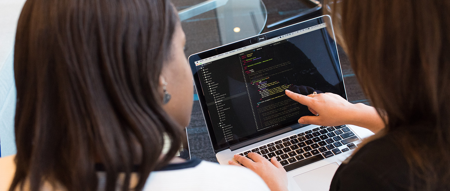 two app developers performing a code review on their mac