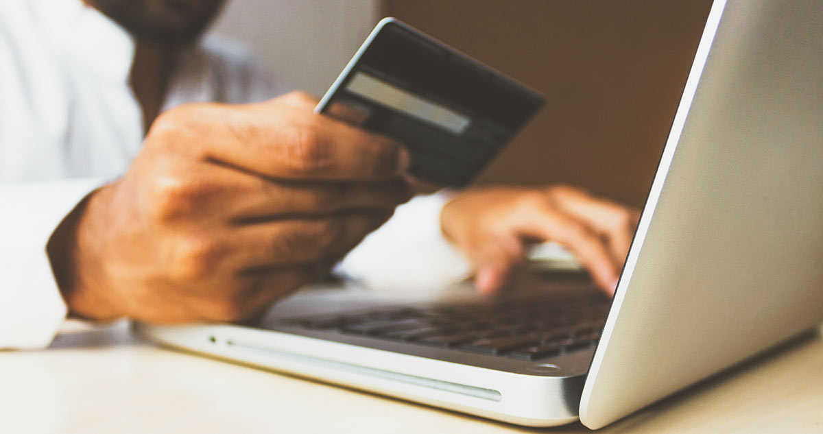 Person paying for something on their laptop using their debit card